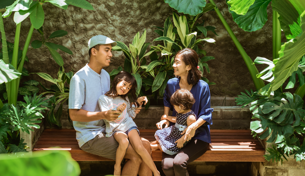 Family sitting together in a tropical garden