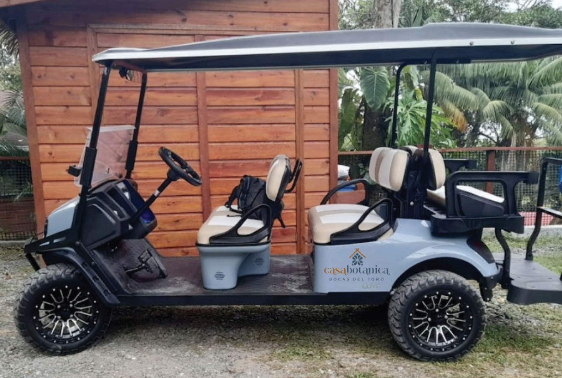 Casa Botanica branded golf cart parked beside wooden building